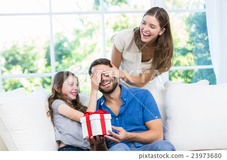 Man surprised with gift in sofa 23973680