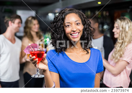 Smiling girl having a cocktail with her friends 23973974