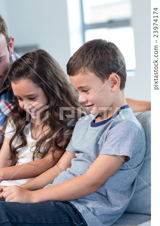 Father and siblings using digital tablet 23974174