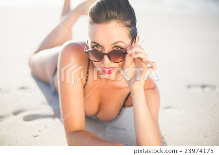 Glamorous woman in bikini lying on the beach 23974175