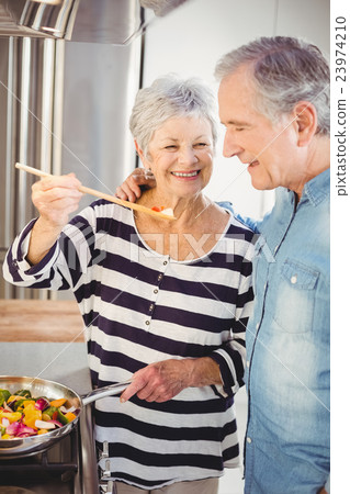 Senior woman feeding food at husband Senior woman feeding food at husband 23974210