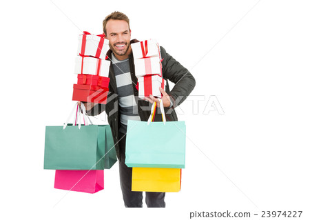 Young man holding gifts and shopping bags 23974227