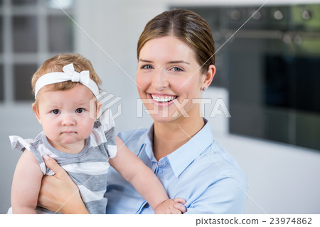 Happy mother carrying daughter at home 23974862