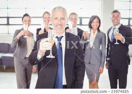Portrait of businessman holding champagne flute 23974885