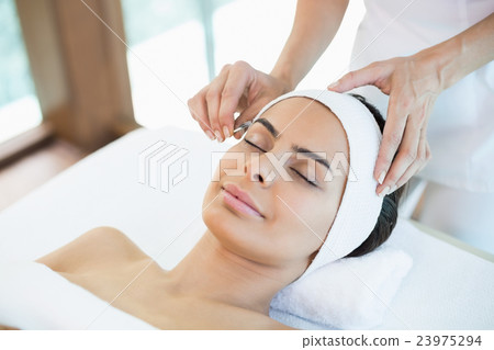 Close-up of beautiful woman receiving facial massage Close-up of beautiful woman receiving facial massage 23975294