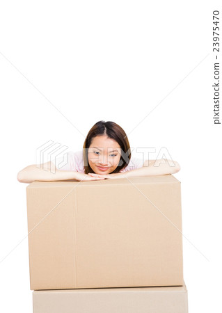 Young woman leaning on cardboard box 23975470