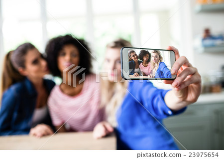 Female friends taking selfie with smart phone 23975654