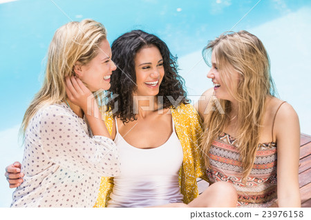 Beautiful women talking near pool side Beautiful women talking near pool side 23976158