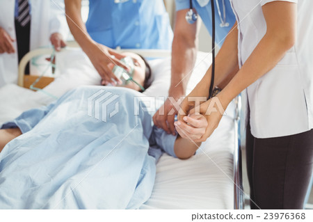 Doctor checking female patient pulse Doctor checking female patient pulse 23976368