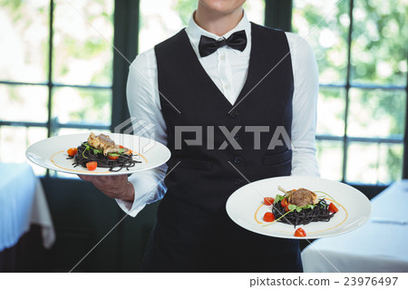 Waitress holding plates 23976497