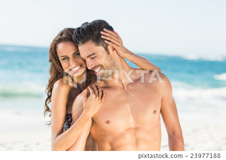 Happy couple hugging on the beach Happy couple hugging on the beach 23977188
