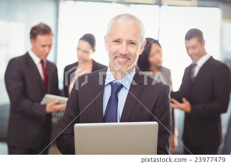 Businessman using laptop in office Businessman using laptop in office 23977479