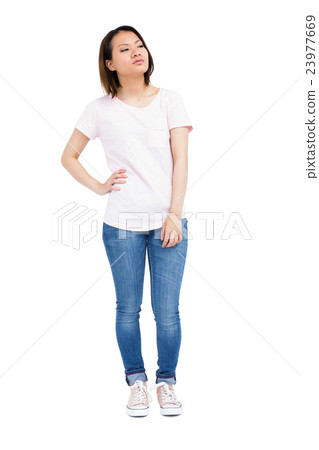 Thoughtful young woman standing with hands on hip 23977669