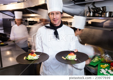 Happy head chef presenting his food plates 23977699