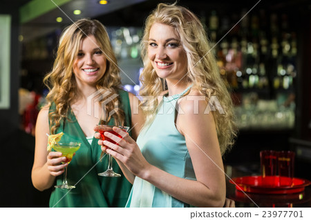Smiling friends drinking cocktails 23977701