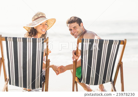 Portrait of young couple sitting on armchair Portrait of young couple sitting on armchair 23978230