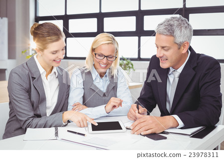 Business people discussing with client over digital tablet 23978311