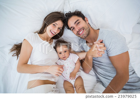 High angle view of happy family lying on bed 23979025