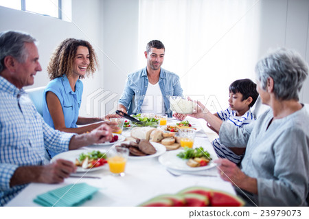Happy family having breakfast together Happy family having breakfast together 23979073