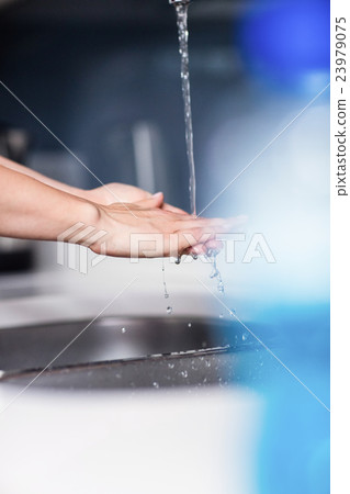 Woman cleaning hands in kitchen at home Woman cleaning hands in kitchen at home 23979075