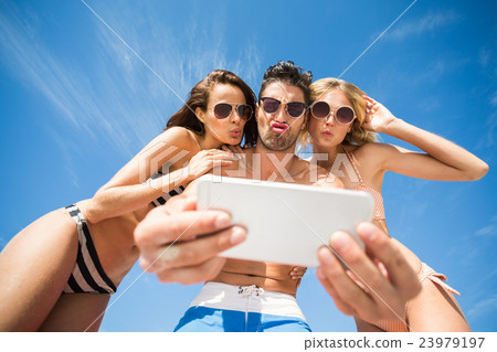 Happy friends taking selfie on the beach 23979197