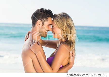 Happy couple hugging on the beach 23979199