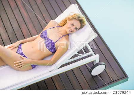 Beautiful young woman relaxing on sun lounger Beautiful young woman relaxing on sun lounger 23979244