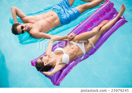 Happy couple relaxing on inflatable raft Happy couple relaxing on inflatable raft 23979245