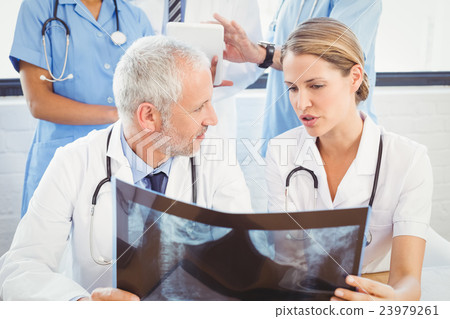 Two doctors examining an x-ray report Two doctors examining an x-ray report 23979261
