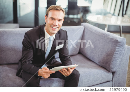 Happy businessman using digital tablet 23979490