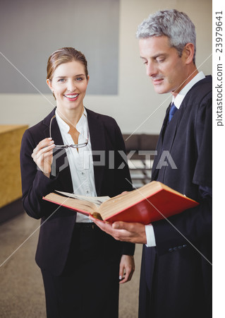 Female lawyer standing by male colleague Female lawyer standing by male colleague 23979641