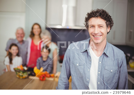 Portrait of young man with family in kitchen 23979646
