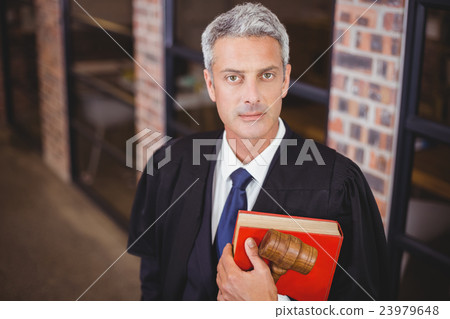 Confident male lawyer with gavel and red book Confident male lawyer with gavel and red book 23979648