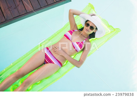 Beautiful woman in bikini lying on air bed in swimming pool 23979838