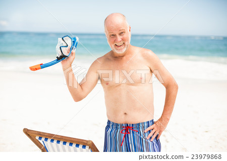 Senior man standing next to sunchair Senior man standing next to sunchair 23979868