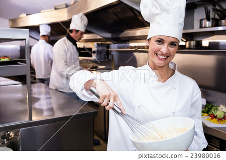 Happy chef whisking bowl of eggs Happy chef whisking bowl of eggs 23980016