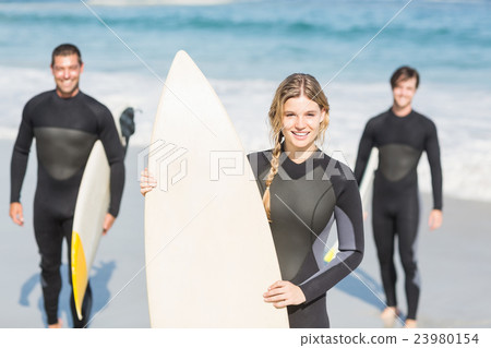 Portrait of surfer friends with surfboard standing on the beach Portrait of surfer friends with surfboard standing on the beach 23980154