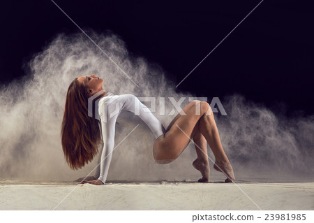 Dancer posing gracefully on the floor in a cloud 23981985