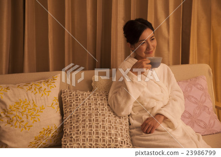 Middle female drinking herb tea before going to bed Middle female drinking herb tea before going to bed 23986799