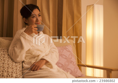 Middle female drinking herb tea before going to bed Middle female drinking herb tea before going to bed 23986802