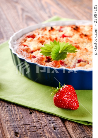 Single harvested strawberry in front of fruit  23987105