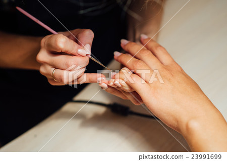 Woman in salon receiving manicure 23991699