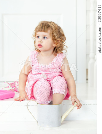 Little cute curly girl sitting on porch Provence Little cute curly girl sitting on porch Provence 23997415