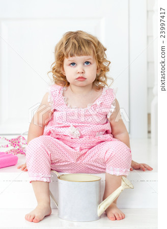 Little cute girl in a pink dress sitting on porch Little cute girl in a pink dress sitting on porch 23997417