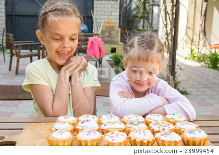 Two sisters with an appetite for looking at home-baked Easter cakes Two sisters with an appetite for looking at home-baked Easter cakes 23999454