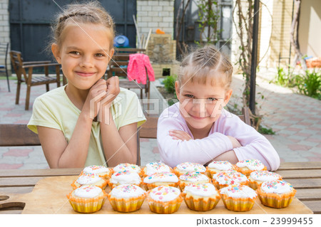 Two girls rejoice freshly baked Easter cupcakes 23999455