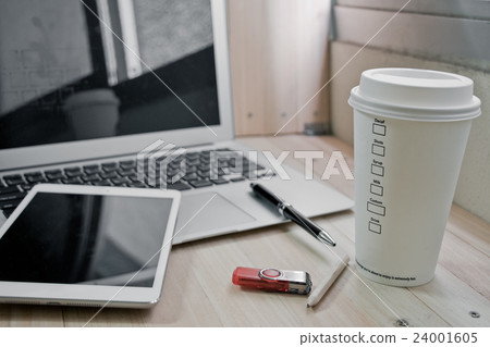 Office supplies with coffee cup, laptop in office 24001605