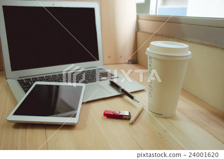 Office supplies with coffee cup, laptop in office 24001620