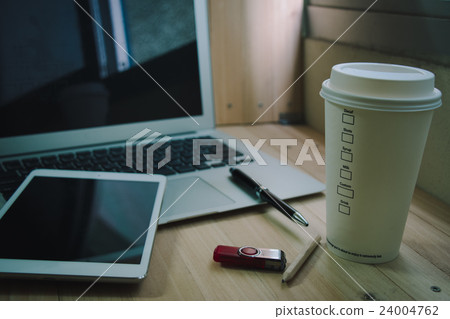 Office supplies with coffee cup, laptop in office Office supplies with coffee cup, laptop in office 24004762