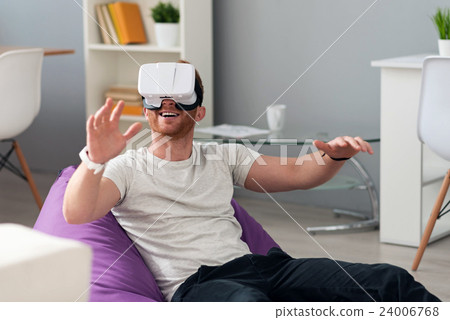 Positive man using virtual reality device Positive man using virtual reality device 24006768